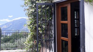 A house with a wooden door and a black metal gate. There is a potted plant next to the gate. - Elegant escape sea view private pool & gardens perfect starting point MTB&hiking (Alassio)