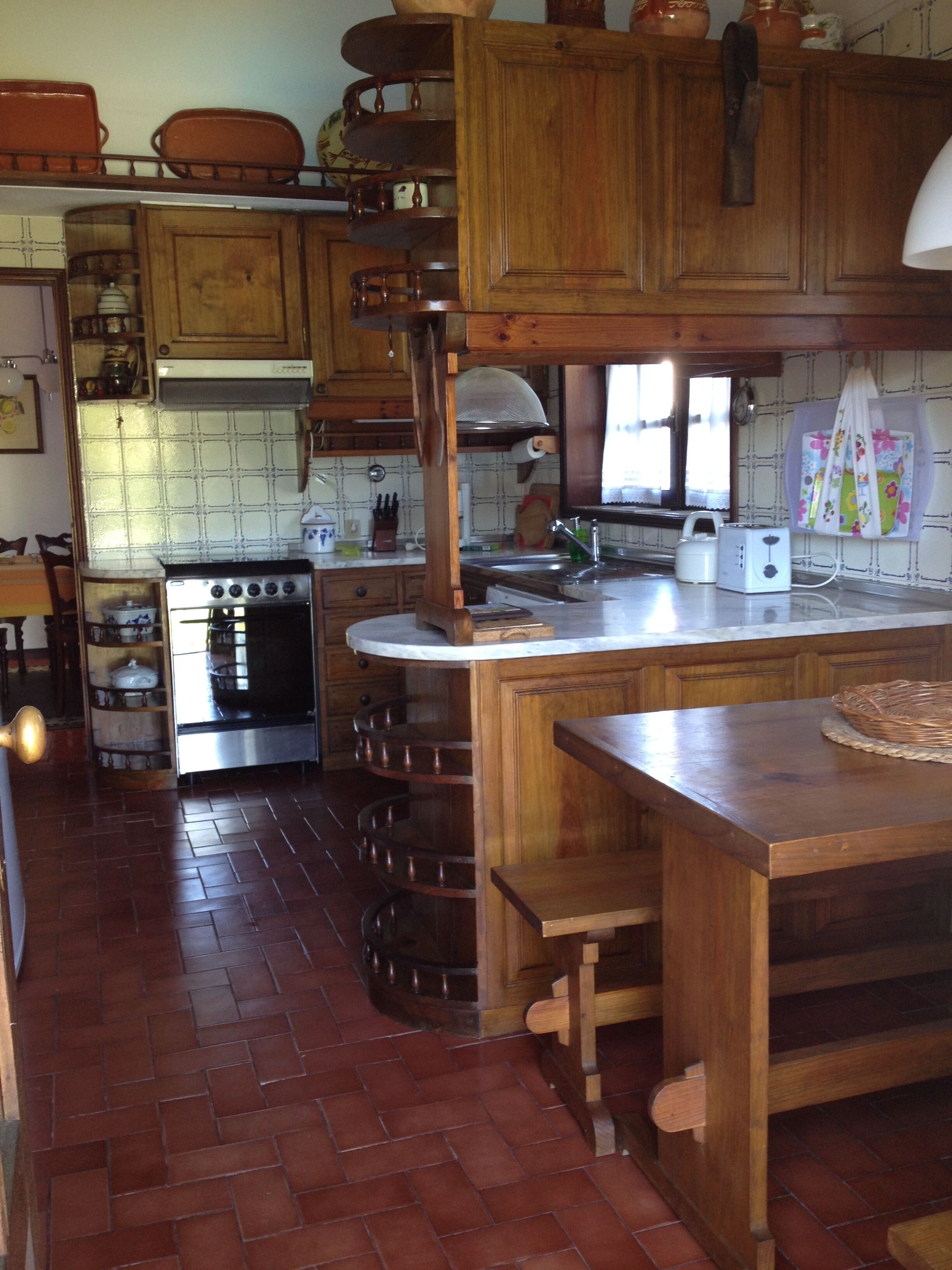 A kitchen with wooden cabinets, a stove, and a sink.