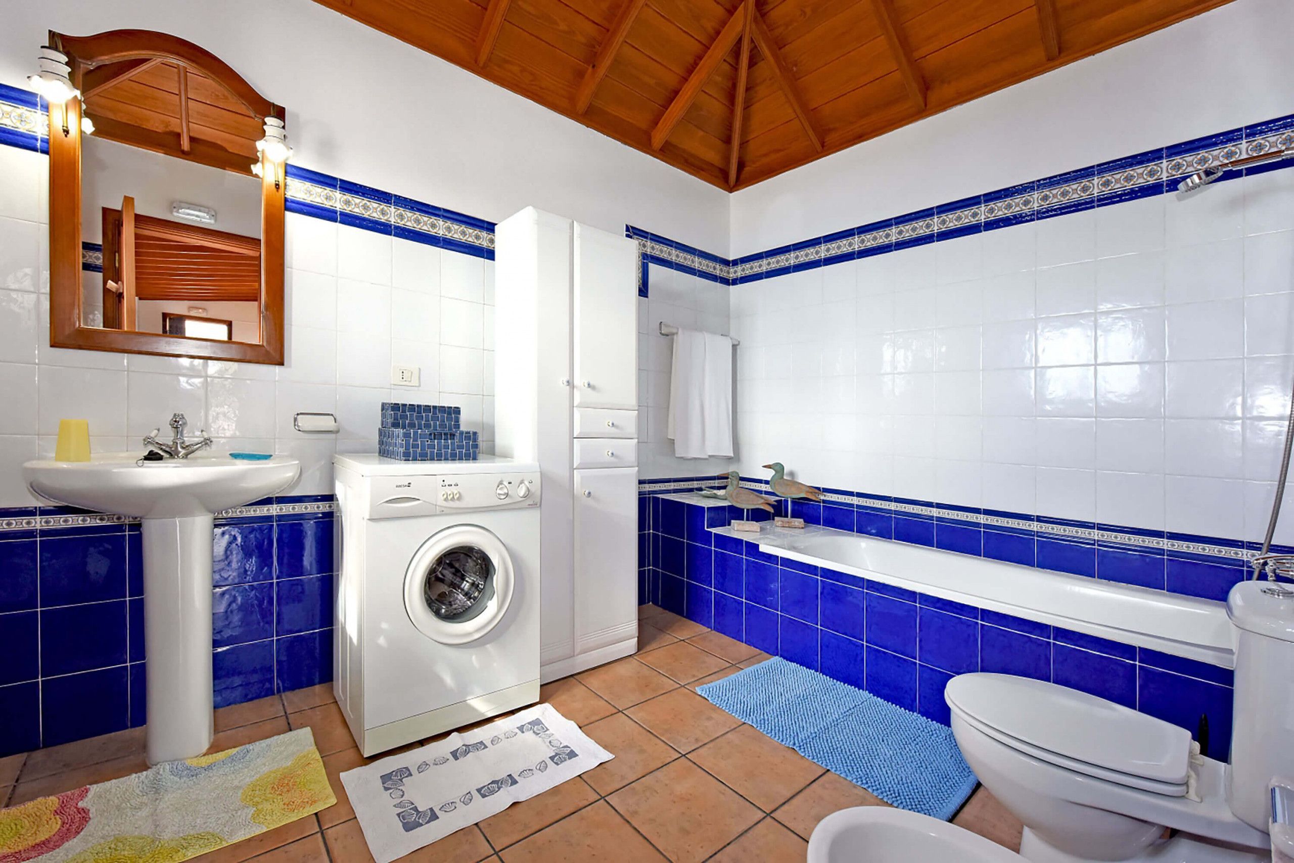 Ein Badezimmer mit Waschmaschine, Waschbecken und Toilette.
