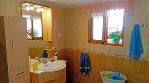 A bathroom with a sink, mirror, and window. - CLASSIC ANDALUSIAN VILLA, SURROUNDED BY ORANGE TREES, FOUNTAINS. PRIVATE POOL. (Órgiva)