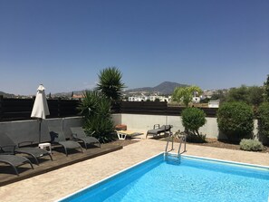 A rooftop pool area with lounge chairs, a small table, and a white umbrella. - Private Pool, Private Location, Free Wifi, All Day Sunbathing in private garden (Alethriko)