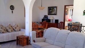 Un salon comprenant un canapé, une table basse et un coin repas avec des chaises et une table.