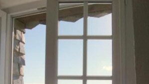 Ein Zimmer mit großem Fenster und Blick auf eine Küstenlandschaft.
