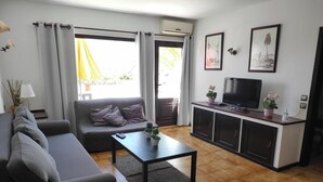 A modern living room with a sofa, a coffee table, a TV, and a cabinet.