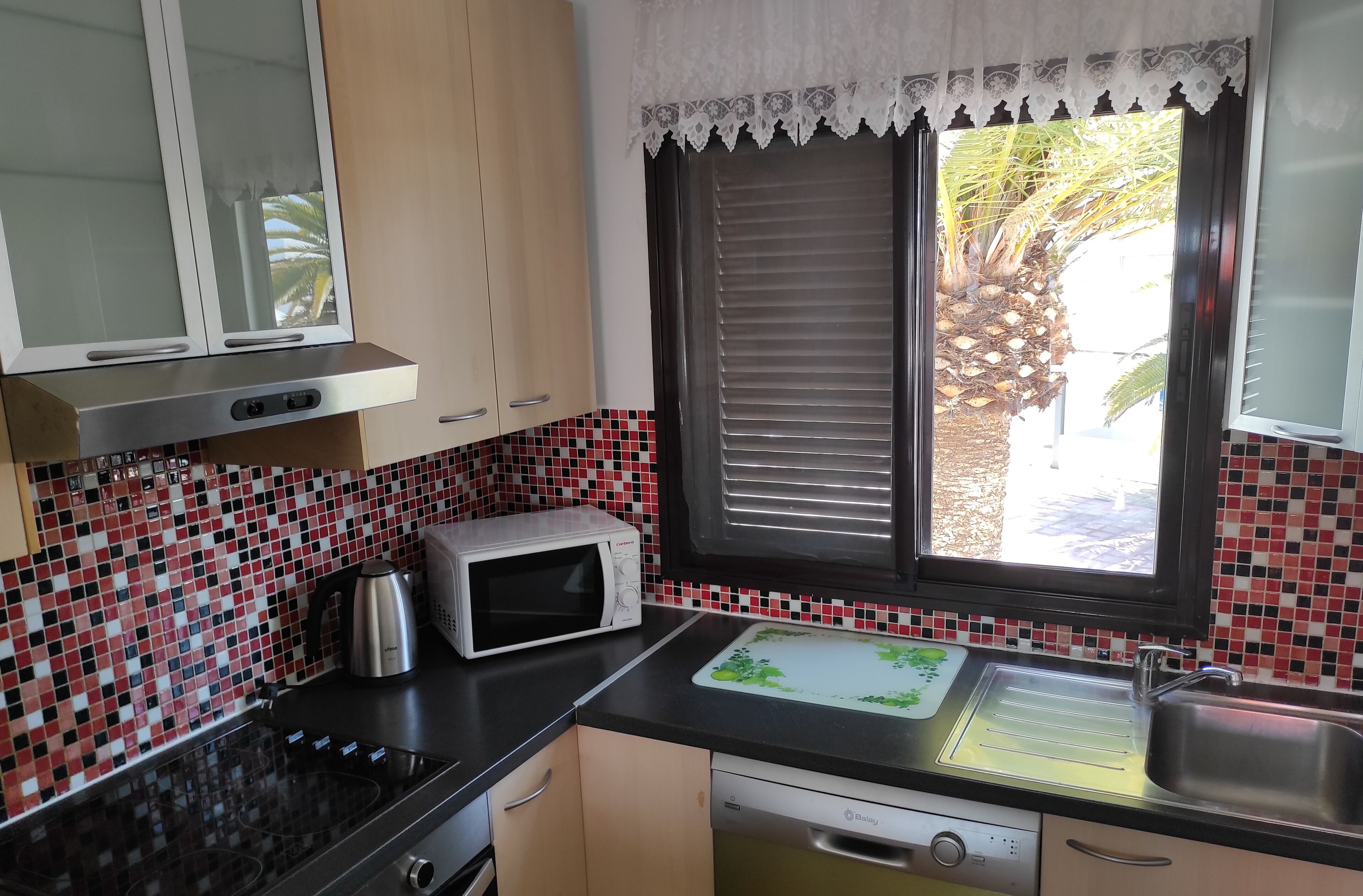 A kitchen with a microwave, stove, and sink.