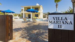 A villa named "Villa Mariana II" with a pool area, lounge chairs, and umbrellas. - 5 Bed, 5 Bath Villa with Private Pool in Affluent Residence of Sea Caves (Paphos)