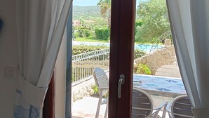 A room with a sliding glass door leading to an outdoor patio with a table and chairs.
