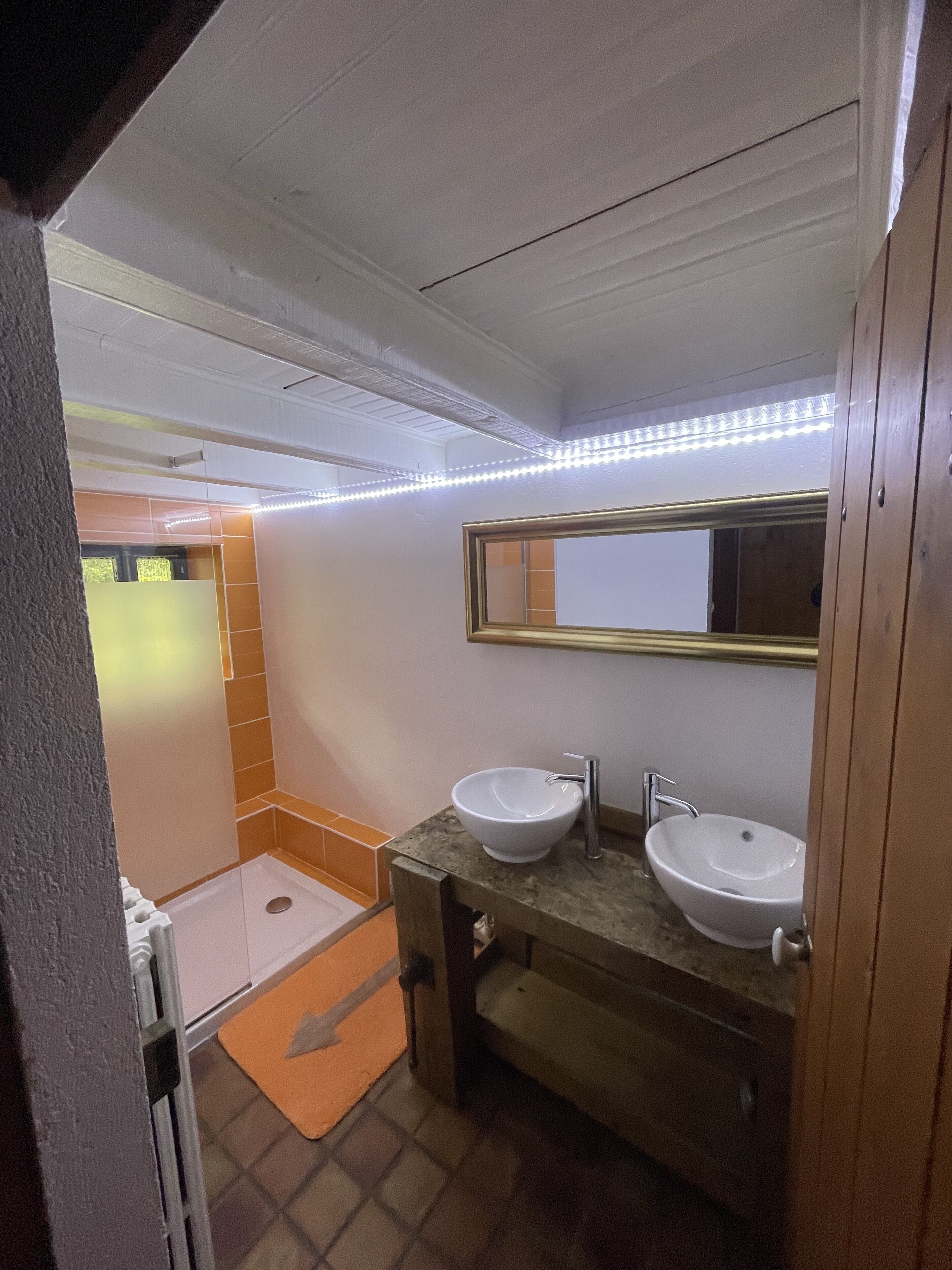Une salle de bain avec deux lavabos, une douche et des toilettes.