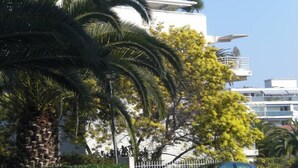Um edifício moderno com fachada branca, varanda e céu azul límpido.