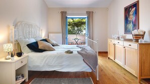 A bedroom with a bed, bedside table, lamp, and a view of the outdoors. - Villa Nina in Vodnjan (Vodnjan)