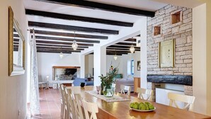 A spacious dining area with a wooden table and chairs, a brick wall, and a fireplace. - Villa Nina in Vodnjan (Vodnjan)
