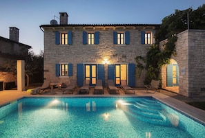 A stone building with a swimming pool, outdoor seating, and a well-lit entrance. - Villa Nina in Vodnjan (Vodnjan)