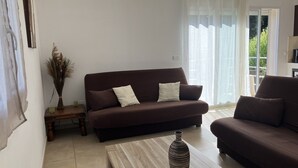 A living room with a brown sofa, a wooden coffee table, and a vase.