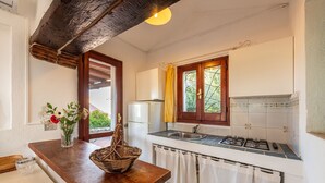 Eine Küche mit Holzarbeitsplatte, Spüle, Herd und einem Fenster mit Vorhängen.
