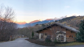 A rustic wooden building with a sloped roof, surrounded by a wooden fence and a small evergreen tree. - Huge Chalet in Combloux, sleeps up to 14, 5mins access to huge Evasion ski area. (Combloux)