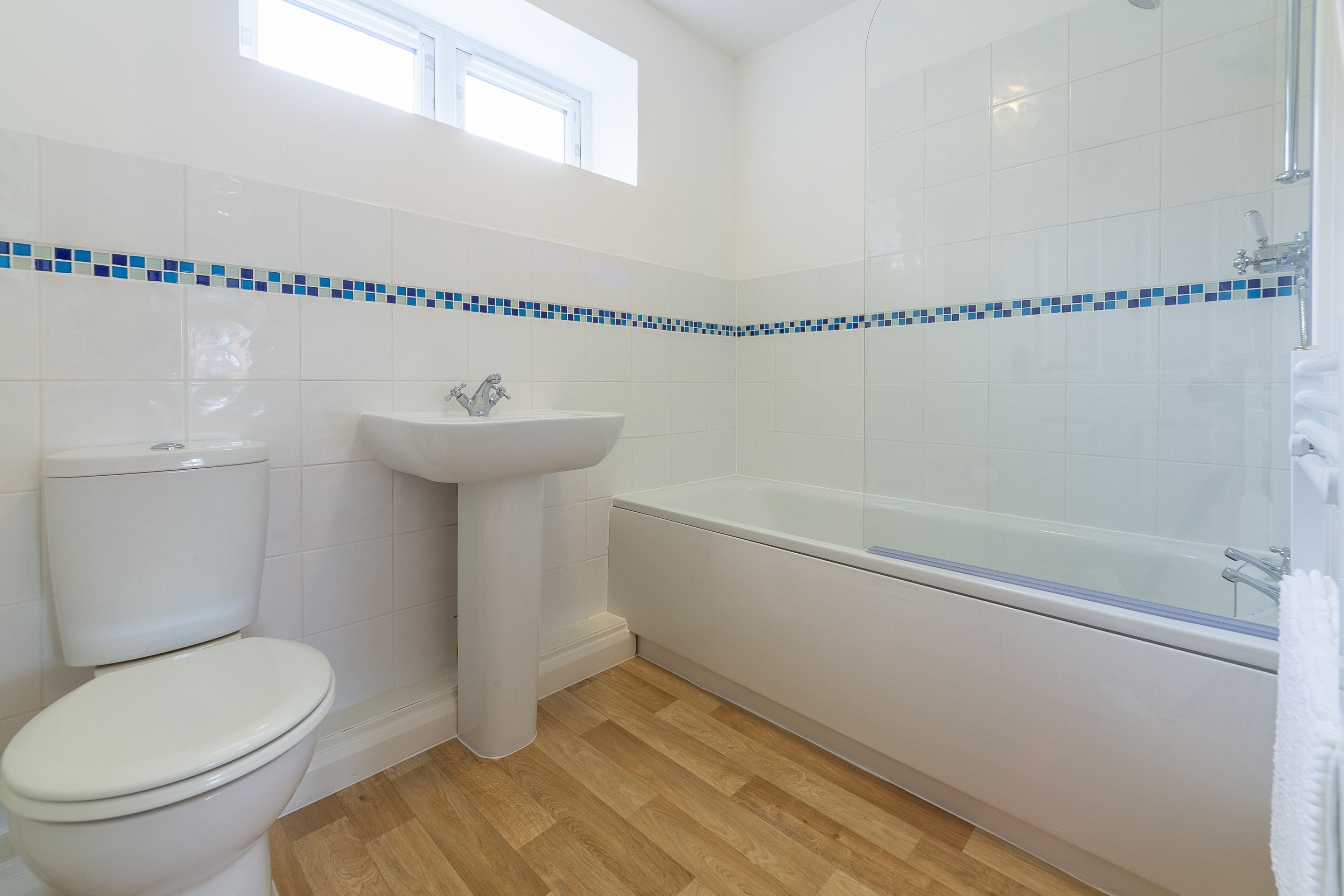 A bathroom with a toilet, sink, and bathtub.