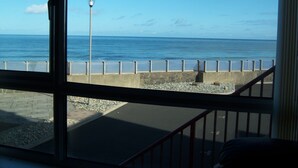 A view from inside a building looking out to the sea through large windows. - Sea front Apartment In Castlerock, With Stunning Panoramic Views (Castlerock)