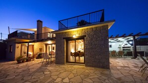 A stone building with a balcony and a covered patio area.