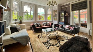 Un salón espacioso con chimenea, ventanas amplias y una zona de estar acogedora.