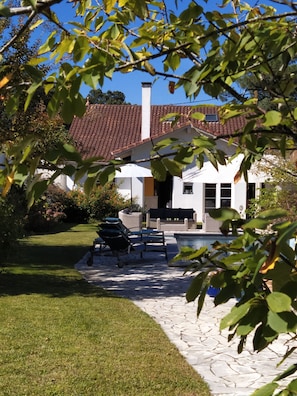 A house with a tiled roof, a swimming pool, and outdoor furniture. - Villa with heated swimming pool and garden close to beaches and golf, quiet area (Capbreton)