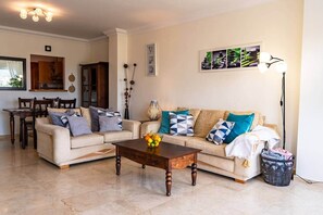 A living room with two sofas, a coffee table, a dining area with chairs, and a lamp. - Peaceful La Cala Retreat Mountains Pool Golf Beach (Mijas)