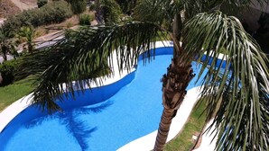 Ein Swimmingpool mit blau-weißem Design, umgeben von Palmen.