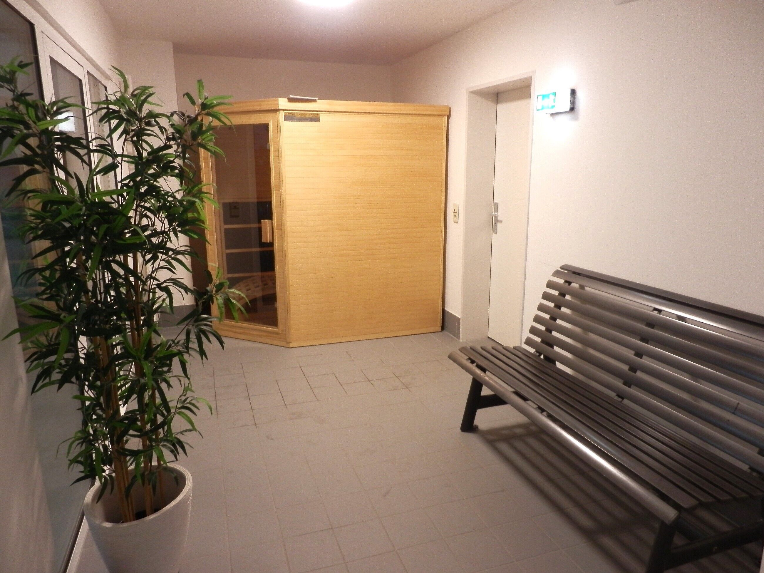 Ein Flur mit Holztür, einer Bank und einem Blumentopf.