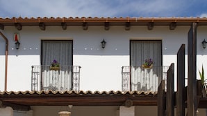 A building with a tiled roof, two balconies with wrought iron railings, and a small entrance with a door and a hanging basket. - House / Villa - Avola (Avola)