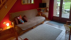 A cozy living room with a sofa, a TV, and a wooden staircase. - With Stunning Views, A Great Location For Mountain Activities And Relaxing (Campan)