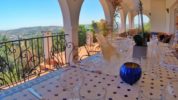 Terraza con una mesa lista para comer, con vistas a un paisaje pintoresco.