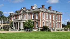A large, historic building with a symmetrical facade, large windows, and a central entrance with columns.