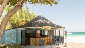 A small, blue and brown beachside grill with a sign reading "Shane's Grill" and two blue chairs in front. - The beautuful Butterfly Villa situated in the exclusive Silver Sands estate (Duncans)