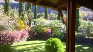 A garden with various plants and a stone wall. -  Spacious villa,  180* ocean view, large heated pool, 5 min from Calheta beach (Calheta)