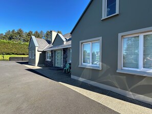 A residential property with a paved driveway, a stone facade, and a green door. - Luxurious Modern Country House in private area with stunning views of Killarney  (Killarney)