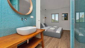 Ein modernes Badezimmer mit einem großen weißen Waschbecken, einer Holzausstattung und einem Spiegel mit Holzrahmen.