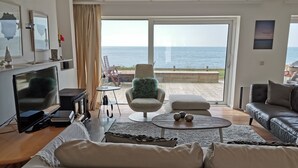 A modern living room with a large window offering a view of the sea. - A very special place (Co. Cork)