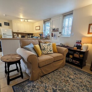 A cozy living room with a sofa, a small table, and a patterned rug.