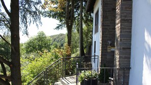 A staircase leading to a building with a brick facade, surrounded by trees and greenery. - Cozy, comfortably furnished apartment for up to 7 people with balcony (Immerath)