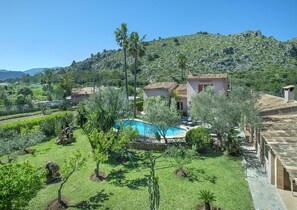 Une villa dotĂ©e dâune piscine, entourĂ©e dâune vĂ©gĂ©tation luxuriante et offrant une vue sur un paysage montagneux.