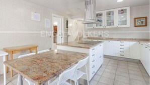 Een moderne keuken met witte kasten, granieten aanrecht en een inbouwfornuis.