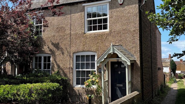 A traditional brick house with a black front door, a small porch, and a chimney. - Spacious 3 bed holiday cottage in Hunstanton only 150 metres to the beach. (Hunstanton)