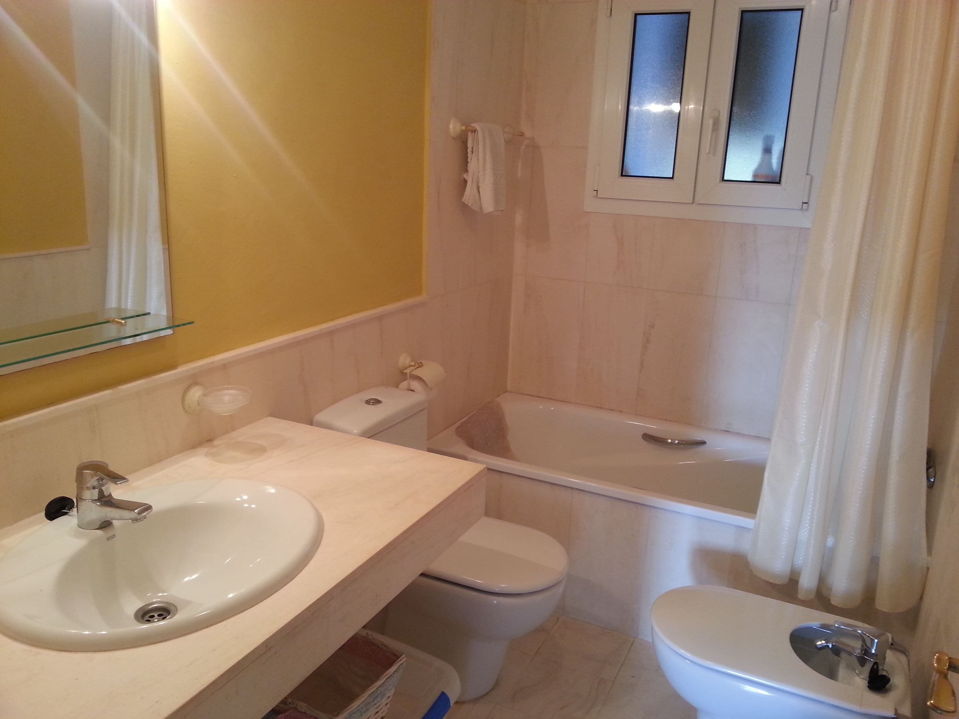 Een badkamer met een wastafel, toilet en bad.