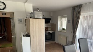 A compact kitchen with a microwave, oven, and a small window. - Great apartment with good facilities in a prime location in Schillig (Wangerland)