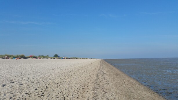 A wide sandy beach with a clear sky. - Great apartment with good facilities in a prime location in Schillig (Wangerland)