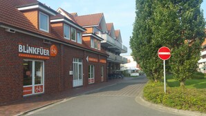 A brick building with a sign for 'Blinkfuer Fahrradvermietung'. - Great apartment with good facilities in a prime location in Schillig (Wangerland)