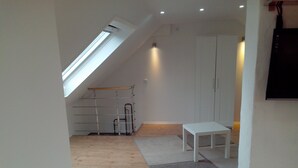 A room with a sloped ceiling, a skylight, a white wardrobe, a small white table, and a metal shelving unit. - in a good location to Dusseldorf and Cologne and the JEVER Skihalle Neuss (Grevenbroich)