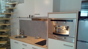 A modern kitchen with a built-in oven, a stainless steel sink, and wooden shelves. - in a good location to Dusseldorf and Cologne and the JEVER Skihalle Neuss (Grevenbroich)