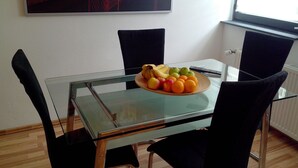 A dining area with a glass table, black chairs, and a fruit plate. - in a good location to Dusseldorf and Cologne and the JEVER Skihalle Neuss (Grevenbroich)