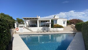 A modern house with a swimming pool, outdoor seating, and a staircase leading to the entrance. - Stylish, spacious and airy, in a quiet area  but close to beach, restos & shops (Sant Lluís)