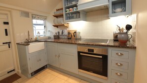 A kitchen with light blue cabinets, a Bosch oven, and a countertop with various kitchen items.